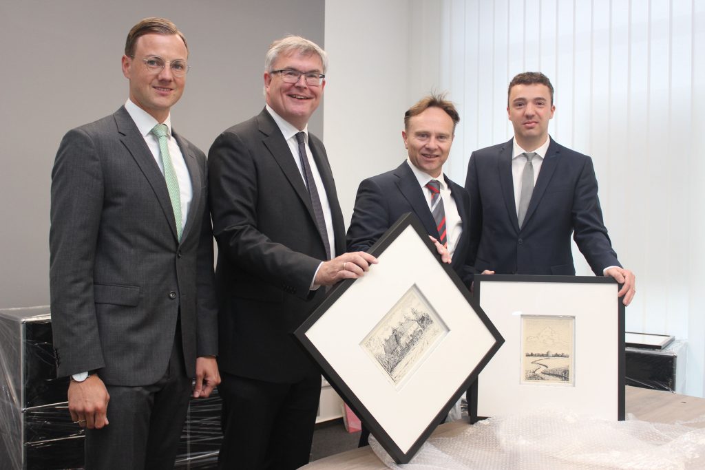Landrat Dr. Kai Zwicker als Verwaltungsratsvorsitzender (3.v.r.) und Vorstandsmitglied Jürgen Büngeler freuen sich über Motive aus Heek und Nienborg, die im neuen Beratungscenter zu sehen sein werden, hier mit Filialdirektor Christian Niehues (rechts) und Andre Könning.