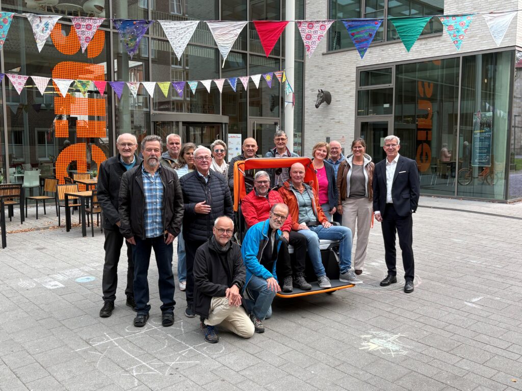 Sparkassen-Vorstandsvorsitzender Norbert Hypki (rechts) und Willi Wessels (5. v. l.) nahmen für das Stiftungskuratorium zusammen mit ehrenamtlichen Fahrerinnen und Fahrern die neue Rikscha am Tag der Auslieferung in Augenschein.
